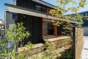 大津市周辺の注文住宅事例：焼杉の佇まいと緑が街を包む、角地ならではの開放感のある家