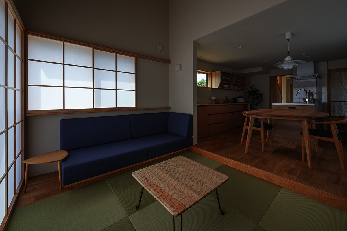 Living room with tatami mats, a navy sofa, and a wooden low coffee table; shoji screens filter soft light into the space.